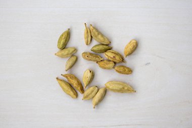 Cardamom seeds isolated on a wooden background. Its scientific name is Elettaria cardamomum. It is also known as Elachi.Top view. clipart