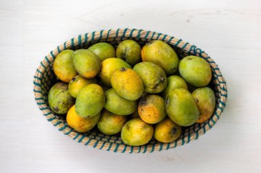 Taze mangolar sepette. Güzel el yapımı hasır sepet olgun mangolarla dolu. Üst görünüm.