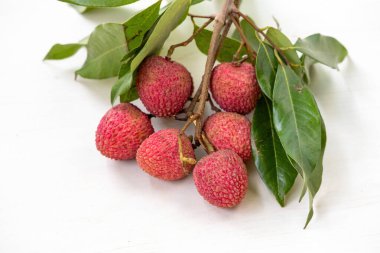 Beyaz arka planda yeşil yapraklı bir grup taze lychees. Litchi chinensis, yaygın olarak lychee olarak bilinir..