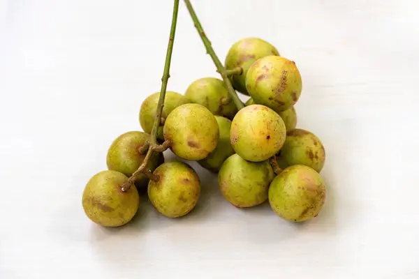 Stock image Bunch of Rambai or Rambi fruits isolated on light wooden surface. It's scientefic name is Baccaurea motleyana. Locally In Bangladesh, It is known as Lotkon, Lotka, or Bugi. Sweet and sour taste.