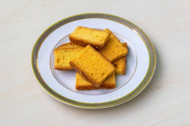 Tahta arka planda beyaz bir tabakta lezzetli kuru kek bisküvileri..