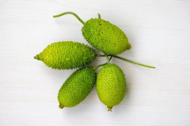 Ahşap arka planda taze dikenli yeşil sebze. Momordica dioica, Kakrol, Kartoli, Kankoda, Kantola olarak da bilinir. Üst görünüm.