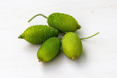 Ahşap arka planda taze dikenli kabak sebzesi. Momordica dioica, Kakrol, Kartoli, Kankoda, Kantola olarak da bilinir..