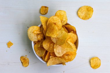 Çıtır çıtır ve lezzetli patates cipsi ya da ahşap arka planda cips. Lezzetli görünümde İspanyol domates tango aromalı patates cipsi var..