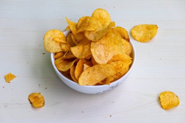 Çıtır çıtır ve lezzetli patates cipsi ya da ahşap arka planda cips. Lezzetli İspanyol domates tango aromalı patates cipsi..