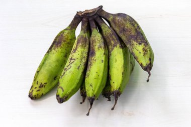 Bunch of fresh raw banana or green banana on light wooden surface. clipart