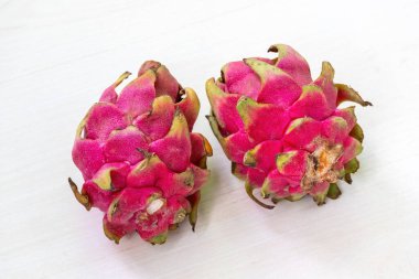 Beyaz arka planda iki ejderha meyvesi.