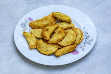 Lezzetli etli etli etli puli pitha. Bangladeş 'ten popüler ve geleneksel bir pirinç keki. Çoğunlukla pirinç unu ve balık, sebze, et veya hindistan cevizi ve jaggery dolgularından oluşur..