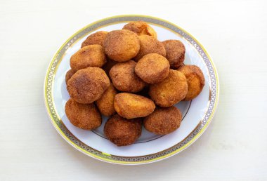 Delicious homemade semolina cake or sujir pitha in a white plate on a light wooden surface. It is traditional food from Bangladesh and the Bengal region of India. clipart