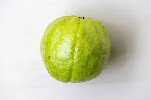 stock image Fresh guava fruit on light wooden surface. Top view.