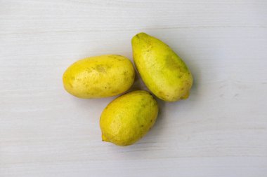 Tahta bir yüzeyde olgunlaşmış sarı limonlar. Üst görünüm.