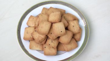 Tahta arka planda beyaz bir tabakta lezzetli siyah kimyon bisküvileri..