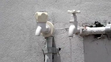 Plastik musluklardan su akıyor, evin çatısına yıkama için ek su muslukları yerleştiriliyor..