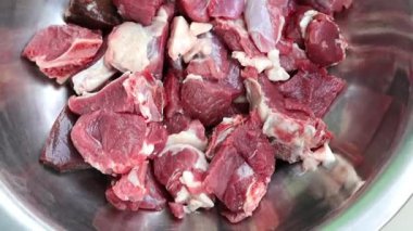 Gümüş bir kasede taze taze koyun eti dilimleri. Canlı kırmızı ete yakın çekim, pişirmeye hazır..