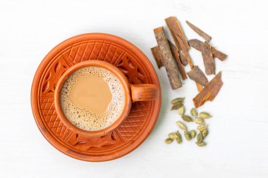 A cup of hot masala tea or masala chai in a traditional clay cup. Top view. clipart