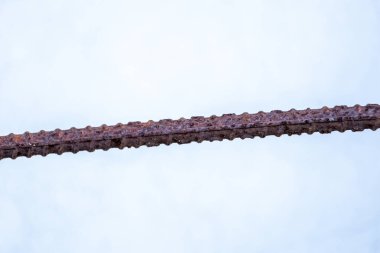 Bulanık beyaz arkaplanda paslı çelik çubuğun yakın çekimi.