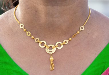 Madalyonla süslenmiş güzel bir Asyalı kadının boynuna yakın çekim. Güzellik ve moda aksesuarlar. Kolyesi olan modern lüks altın kolye.