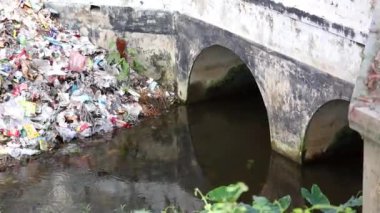 Atık su kanalizasyondan akar ve nehre gider. İnsanlar buraya çöp atarak çevreyi bozuyorlar. Çevre ve su kirliliği kavramı.