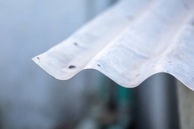 Bulanık bir arka planı olan eski bir demir çarşafın yakın çekimi. Bangladeş 'te bir köy evinin çatısındaki galvanize Dhew tenekesinin dalgalı dokuları.