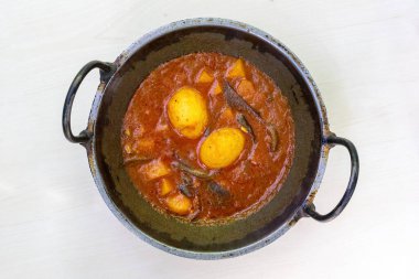 Spicy dim bhuna or dim vuna, cooked with potatoes in a karai. This delicious Bengali boiled egg curry is often enjoyed with rice or bread. clipart