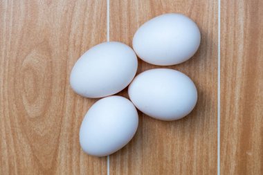 White chicken eggs on a wooden background. These eggs are naturally reared country chicken eggs in the village home of Bangladesh. Top view. clipart