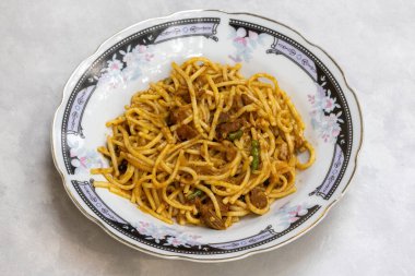 Homemade tasty beef chowmein noodles served in a white ceramic plate. clipart