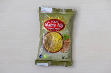 Packets of Bashundhara coriander powder (50g) displayed on a light wooden surface. A quality product from the renowned Bashundhara Group. clipart