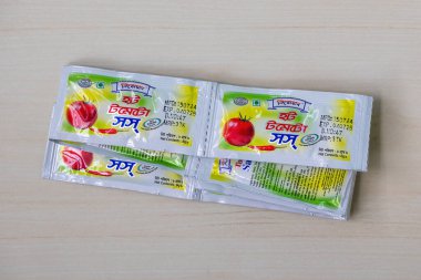 Tahta bir yüzeye yerleştirilmiş mini paket sıcak domates sosu. Kishwan 'ın bir ürünü, Bangladeş' te tanınmış bir gıda işleme grubu..
