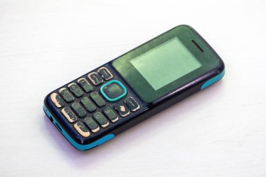 Beyaz arka planda izole edilmiş, eski, düğme tarzı bir cep telefonu..