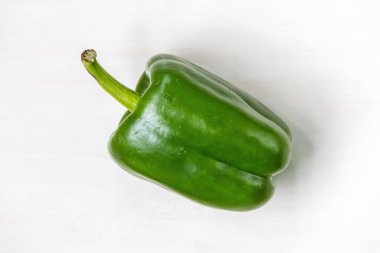 Beyaz arka planda izole edilmiş taze yeşil dolmalık biberin üst görüntüsü. Ayrıca kırmızı biber, biber, biber, biber, kırmızı biber veya kırmızı biber olarak da bilinir..