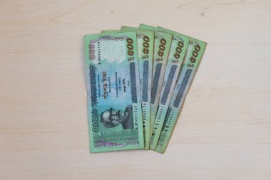 Tahta bir arka planda gösterilen 500 Taka Bangladeş para birimi notu.