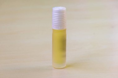 Ahşap bir yüzeyde saklanmış doğal parfüm şişesi. Attar çeşitli çiçek, yaprak, ağaç kabuğu, tohum ve diğer bitkilerden elde edilen yağlardan elde edilen doğal bir parfümdür..