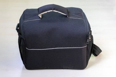 Beyaz arka planda siyah bir çanta. Bu çok yönlü çanta kameralar, seyahat, defterler ve günlük kullanım için idealdir..