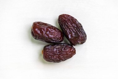 Beyaz arka planda üç taze, kurumuş tarih var. Üst görünüm.