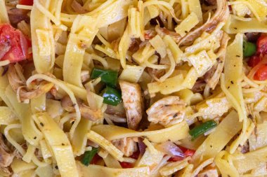 Arka plan olarak lezzetli tavuklu eriştenin yakın plan çekimi, lezzetli tavuk eti, canlı yeşil biber, sulu domates ve taze soğanlı eriştenin leziz dokusunu gözler önüne seriyor..