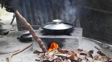 Geleneksel kil sobada köri pişirmek. Bangladeş 'te kuru yapraklar ve inek gübresi çubukları. Gümüş kapakla kaplı buhar pişerken yükselir, sarı bir alev ve duman yaratır..