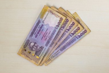 Bangladeş 1000 taka banknotları (BDT 1000) tahtadan bir arka planda izole edildi.