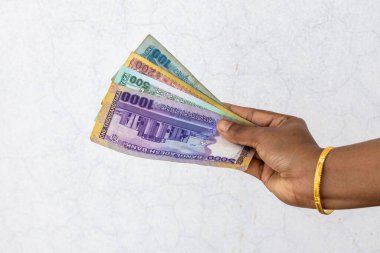 Kadın eli 1000, 500, 200 ve 100 taka Bangladeş banknotlarını gösteriyor (BDT)