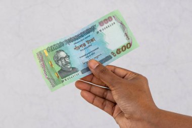500 taka Bangladeş banknotu tutan bir kadın.