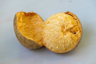 Olgun ahşap elma ya da bael meyvesi, sulu etini ortaya çıkarmak için kırılmış olarak gösterilir. Bilimsel adı Aegle marmelos, ayrıca taş elma, Bengal quince, Hint quince veya Bel olarak da bilinir.