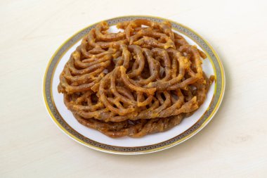 Lezzetli Shahi jilapi ya da beyaz seramik tabakta jalebi. Eski Dhaka, Bangladeş 'teki Chowk Bazaar' dan kaynaklanan popüler ve geleneksel bir tatlıdır ve ülkede çok popülerdir..