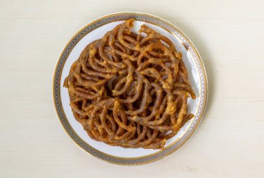 Lezzetli Shahi jilapi ya da jalebi beyaz bir tabakta servis edilir. Eski Dhaka, Bangladeş 'teki Chowk Bazaar' dan kaynaklanan popüler ve geleneksel bir tatlıdır. Üst görünüm.