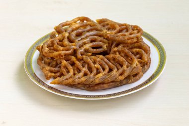 Lezzetli Shahi jilapi ya da beyaz seramik tabakta jalebi. Eski Dhaka, Bangladeş 'teki Chowk Çarşısı' ndan ünlü geleneksel bir tatlı dükkanı olan Shahi jilapi, ülkede çok popüler..
