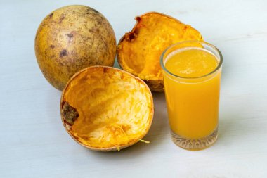 Tahta bir yüzeyde, Şerbet olarak da bilinen bir bardak olgun Bael meyve suyu. Bu ferahlatıcı içecek ahşap elma, taş elma, Bengal quince, Hint quince veya Bel gibi diğer isimlerle de bilinir..