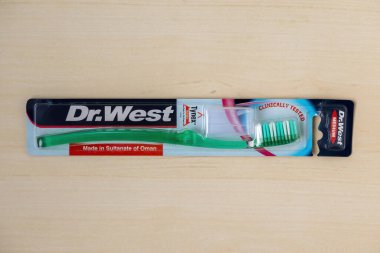 Ahşap arka planda yeşil Dr. West zigzag diş fırçası. Üst görünüm.