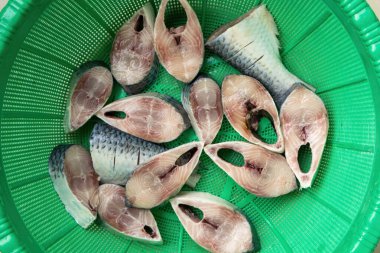 Yeşil sepetteki taze, çiğ Hilsa balığı dilimleri (Tenualosa ilisha) pişmeye hazırdır. Bu dünyaca ünlü balık Bangladeş Padma Nehri 'nden Batı Bengal, Hindistan' da da popülerdir..