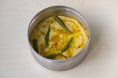 Hafif ahşap bir yüzey üzerinde gümüş çatal bıçakla servis edilen leziz bir kısa dilimleme. Hilsa balığıyla yapılan bu popüler Bengali yemeği hardal tohumlarıyla pişirilir..