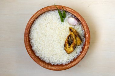 Panta Ilish, Pohela Boishakh için yeşil biberli ve soğanlı geleneksel Bengali Yeni Yıl yemeği. Hilsha 'yı kil tabakta kızarttım. Üst görünüm.