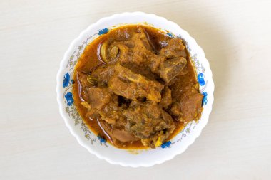 Ahşap bir arka planda beyaz bir kasede lezzetli koyun eti körisi. Koyun bhuna çok lezzetli, baharatlı ve popüler bir Bengali (Bangladeş) yemeğidir. Üst görünüm.