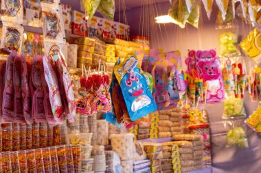 23 Şubat 2025 'te Bangladeş, Kishoreganj' daki uluslararası ticaret fuarı sırasında bir dükkanda asılı duran farklı marşmelov, çikolata ve lolipoplar..